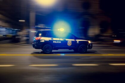 Полицейски автомобил бързащ с включени светлини през нощта.